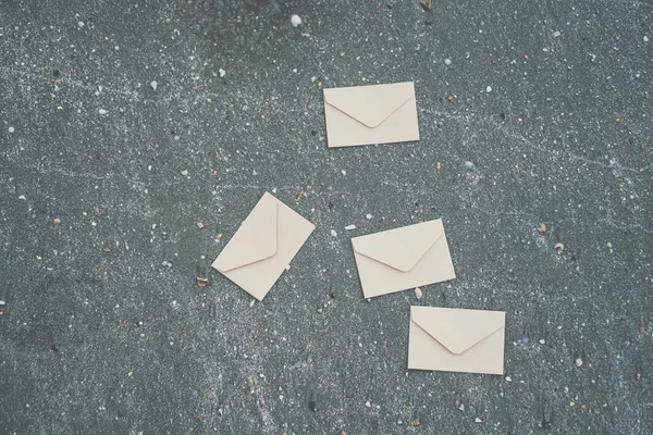 Vele od envelop impliceren voor het verzenden van e-mail op zand textuur achtergrond. — Stockfoto