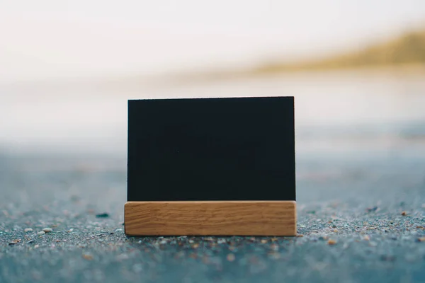 Oscuro pequeño espacio de copia de pizarra en arena con playa . — Foto de Stock