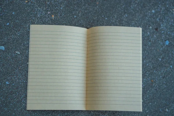 Pequeño cuaderno blanco sobre arena en la hermosa playa textura del mar . — Foto de Stock