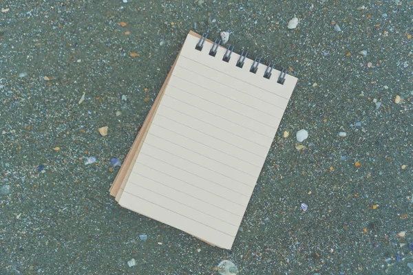 Piccolo notebook bianco su sabbia a bella struttura di mare di spiaggia . — Foto Stock