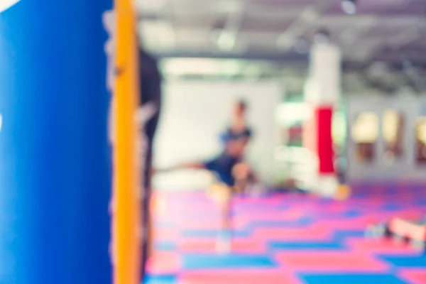 El hombre desenfocado en el gimnasio de fitness está boxeando con fondo de saco de boxeo . — Foto de Stock