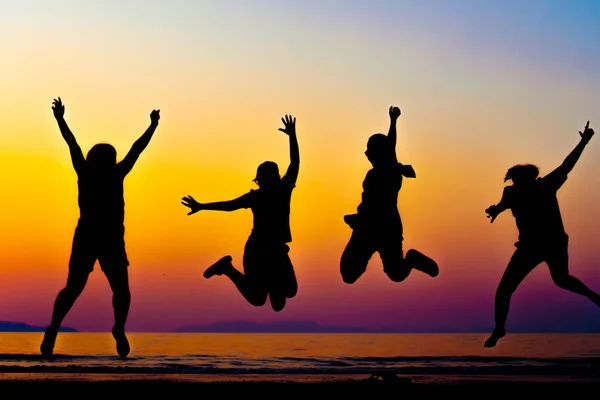 A group of women rise hands up to sky freedom concept with blue sky and beach sunset. — Stock Photo, Image