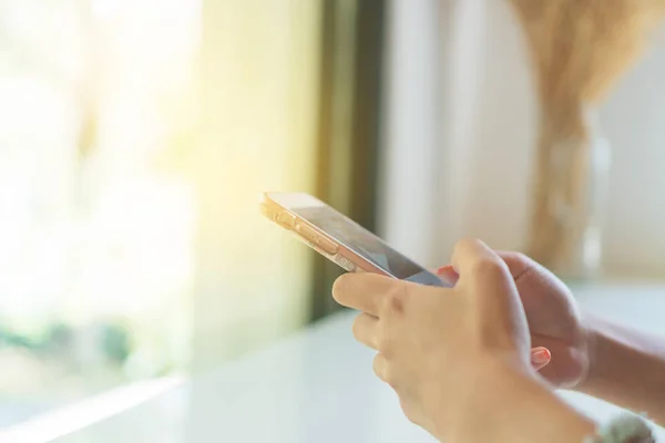 Femme main à l'aide d'un smartphone dans le fond du café boutique. Commerce, finance, marché boursier . — Photo