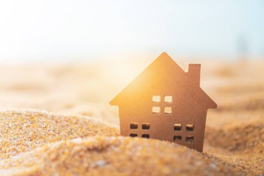 Güneş ışığı arka plan ile yeşil çim üzerinde küçük ev modeli kapalı.