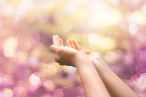 Женщина руки положить вместе, как молиться на зеленом фоне природы
.