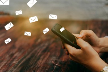 Woman hand using smartphone to send and recieve email.
