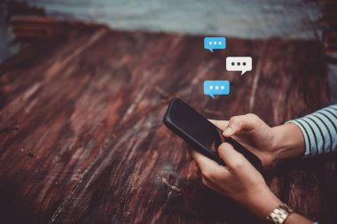 Kadın el yazarak, smartphone kullanarak sohbet sohbet sohbet kutusu simgeleri açılır. Sosyal medya pazarlama kavramı.
