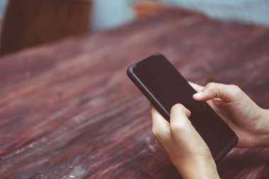 İş yapmak için akıllı telefon ya da tablet kullanan kadın eli.
