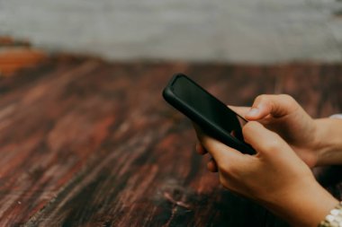 İş yapmak için akıllı telefon ya da tablet kullanan kadın eli.