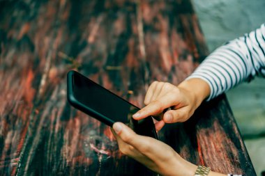 İş yapmak için akıllı telefon ya da tablet kullanan kadın eli.