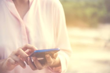 Kadın el kafe salonu güneş ışığı gölge nesnesine güzel ile smartphone ve dizüstü kullanarak arka plan.