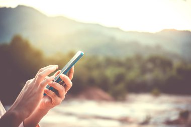 Kadın el kafe salonu güneş ışığı gölge nesnesine güzel ile smartphone ve dizüstü kullanarak arka plan.