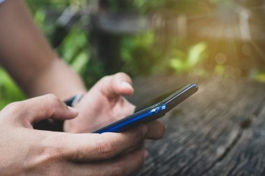 Kadın el iş, mali veya ticaret hisse senedi forex piyasasında park açık doğa yol arka plan yapmak için Smartphone veya tablet kullanarak.