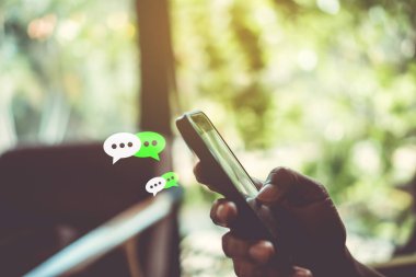 Kadın el yazarak, smartphone kullanarak sohbet sohbet sohbet kutusu simgeleri açılır. Sosyal medya pazarlama kavramı.