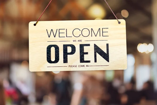 A business sign that says open on cafe or restaurant hang on door at entrance.