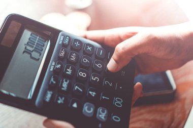 Kadın, gelecekte arka plan olarak blok zinciri içinde kripto para dijital sembolü olarak bir yığın Bitcoin para ile hesap makinesi kullanır.