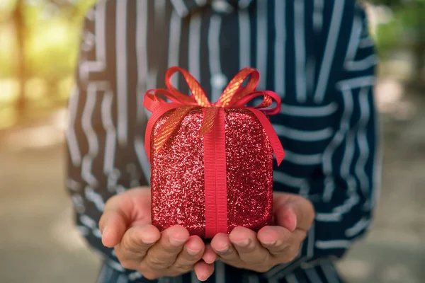 Hand Hold Gift Box Someone Green Bokeh Nature Celebration Holiday — Stock Photo, Image