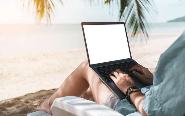 Plaj arka planında tatil malzemelerinde çalışmak için dizüstü bilgisayar ve akıllı telefon kullanan bir kadın. İş, finans, ticaret hisseleri ve sosyal ağ kavramı.
