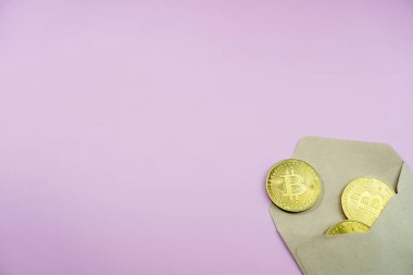 Hediye olarak altın bitcoin paralarla dolu zarf manzarası. Masanın üzerinde büyük altın BTC kripto paraları var..