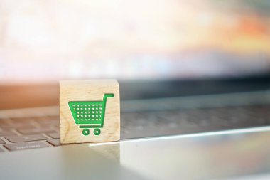 Kapalı bir alışveriş arabası simgesi bilgisayar klavyesinde tahta küpün üzerinde. Çevrimiçi alışveriş teknolojisi kavramı.