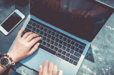 İş kadını elinin modern dizüstü bilgisayarını ya da telefonlu not defterini kullanmasının en iyi görüntüsü. Ofis masaüstü masa arkaplanı.