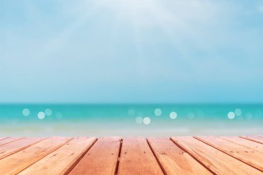 Ürününüzü göstermek için güzel plaj arka planına sahip eski ahşap masanın seçici odağı.
