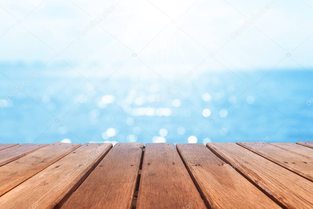 Selective focus of old wood table with blur beautiful beach background for display your product.