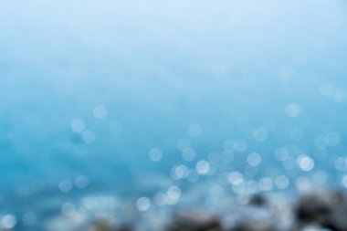 Bulanık yaz Bokeh plajı. Güneş ışığı ve mavi gökyüzü arka planı..