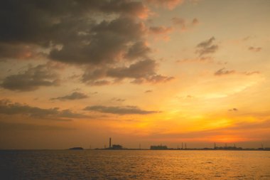 Günbatımı ya da gündoğumu gökyüzü ve sahil Endüstriyel Estate arka planı.