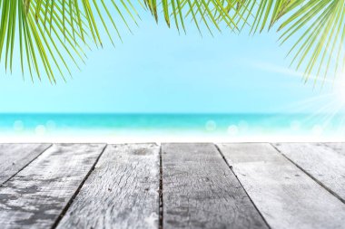 Ürününüzü göstermek için güzel plaj arka planına sahip eski ahşap masanın seçici odağı.