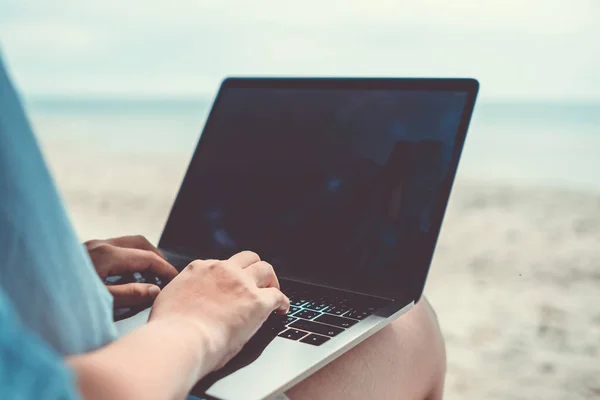 Woman using laptop and smartphone to work study in vacation cady at beach background. Business, financial, trade stock maket and social network concept.