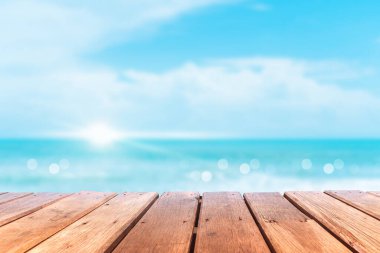 Ürününüzü göstermek için güzel plaj arka planına sahip eski ahşap masanın seçici odağı.