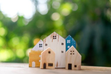 Küçük ev modelini yere ya da güneş ışığı yeşil bokeh arka planlı ahşap masaya kapattım. Deam 'in yaşam ve yatırım konsepti için kendine ait bir mülkü var..