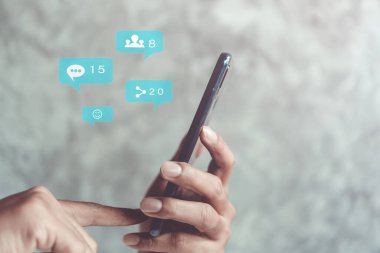 Sosyal medya ve pazarlama sanal simgeleri ekran kavramına sahip akıllı telefonlu klavye yazmak.