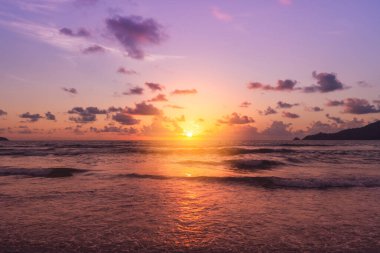 Yaz mevsiminde güneş doğarken ya da günbatımında ışık arka planda olan tropikal doğa denizi ya da plajı.