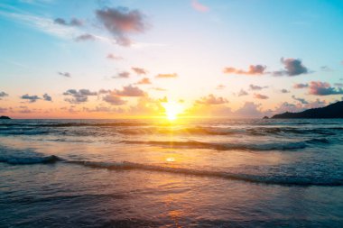 Yaz mevsiminde güneş doğarken ya da günbatımında ışık arka planda olan tropikal doğa denizi ya da plajı.