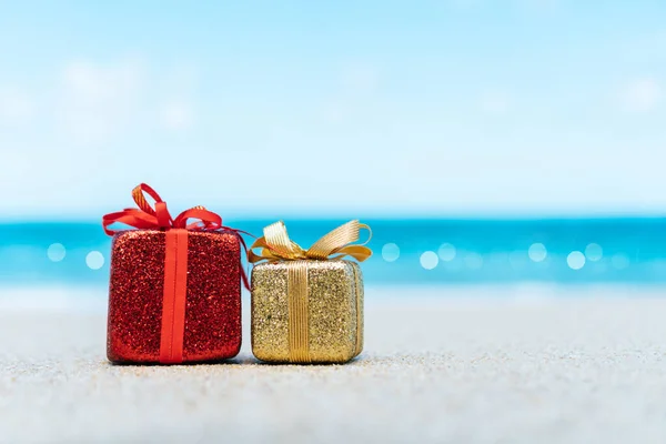 Gift boxes on sandy beach. Hot tours or holiday vacation concept with summer sea background.