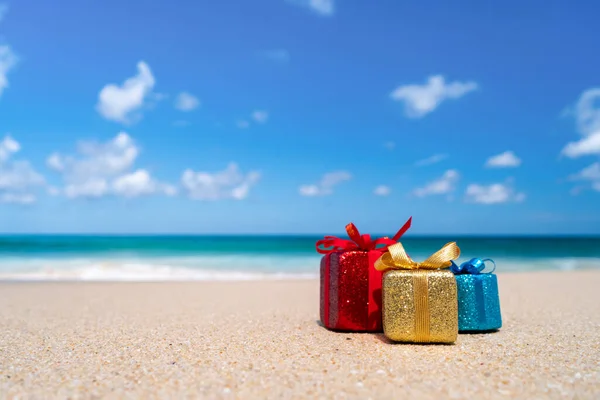 Gift boxes on sandy beach. Hot tours or holiday vacation concept with summer sea background.