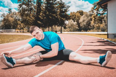 Germe yapan erkek açık hava Atletizm pist alan üzerinde sıcak yaz günü sırasında uygular. Tonlu görüntü.