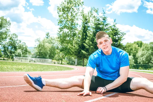 Germe yapan erkek açık hava Atletizm pist alan üzerinde sıcak yaz günü sırasında uygular. Tonlu görüntü.