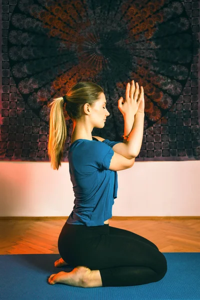 Portrait of gorgeous young woman practicing yoga indoor. Beautiful girl practice yoga in peaceful ambient. Calmness and relax, female happiness.