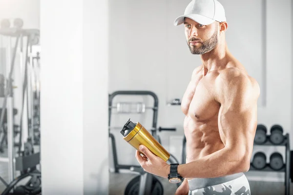 Fti hombre sosteniendo agitador de proteínas en el gimnasio . — Foto de Stock