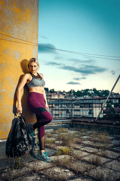 Bionda con borsa fitness sul tetto — Foto Stock