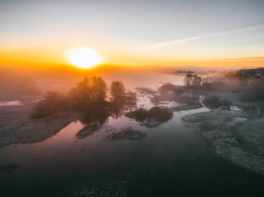 Bahar çayır üzerinde gündoğumu. Bahar hava manzara. Bahar gündoğumu yeşil orman ve nehir ve sis üzerinde.
