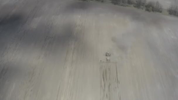 Ansicht von oben: Traktor pflügt trockenes und staubiges Feld und bereitet Boden für die Aussaat vor. — Stockvideo