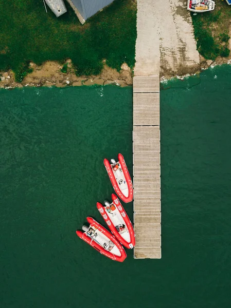 Czerwone nadmuchiwane łodzie stoją w pobliżu przebicia.Widok z lotu ptaka. — Zdjęcie stockowe