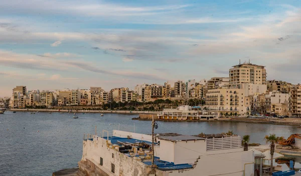 St. Paul Körfezi 'ndeki balıkçı tekneleri ve turist gemileri Bugibba, Malta