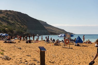 San Blas Beach and Bay, Gozo, Malta : 2019 Mayıs 06 : Güzel turuncu kırmızı kum ve San Blas Beach and Bay, Gozo, Malta berrak masmavi su.