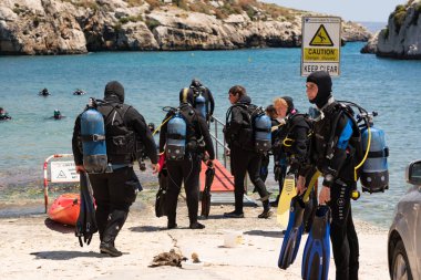 Mgarr Ix-Xini Bay, Malta : 2019 Mayıs 05: Bir grup dalgıç Akdeniz'den Malta'nın Gozo'daki kayalıkların yakınından çıkıyor