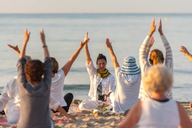 Altafulla, Tarragona, İspanya : 219 Ağustos 31 : Yoga eğitmeni Altafulla, Tarragona, İspanya plajda gün batımında bir grup oturumu lider